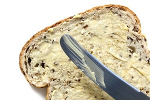 Bread and butter, with knife.  Overhead view, white background.
