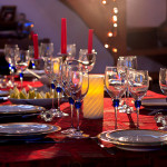 Festive table place setting with china plates, crystal glasses set and ready for guests and food