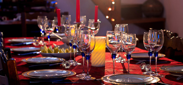Festive table place setting with china plates, crystal glasses set and ready for guests and food