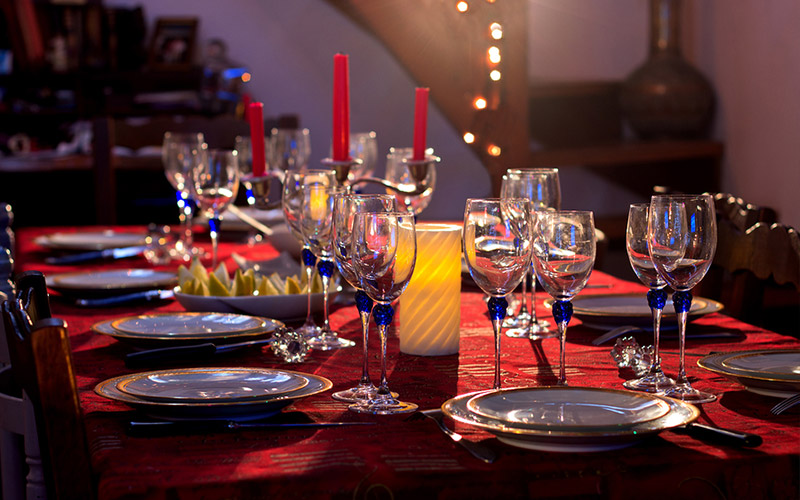 Festive table place setting with china plates, crystal glasses set and ready for guests and food