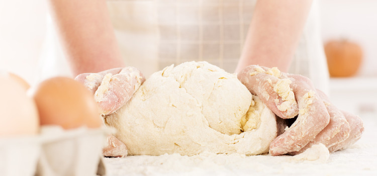 Pair of woman's hands kneading gluten free dough on table. Close-up