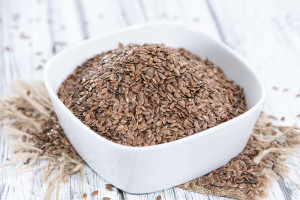 flax seed flour in a sqaure white bowl on a wooden table