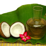 Coconut and coconut oil on a palm leaf with a red flour