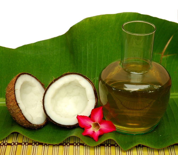 Coconut and coconut oil on a palm leaf with a red flour