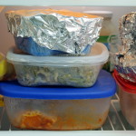 leftover food in plastic and tuperware containers, in the fridge