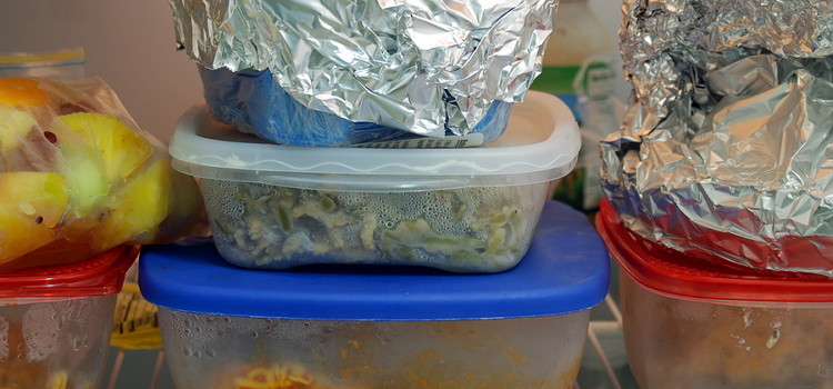 leftover food in plastic and tuperware containers, in the fridge