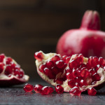 pomegranate that has cut open on black wooden background