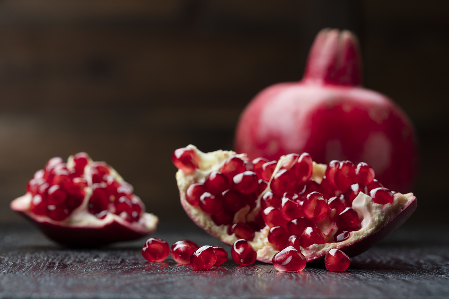 pomegranate that has cut open on black wooden background