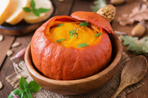 Pumpkin cream soup with peppers and herbs in a pumpkin